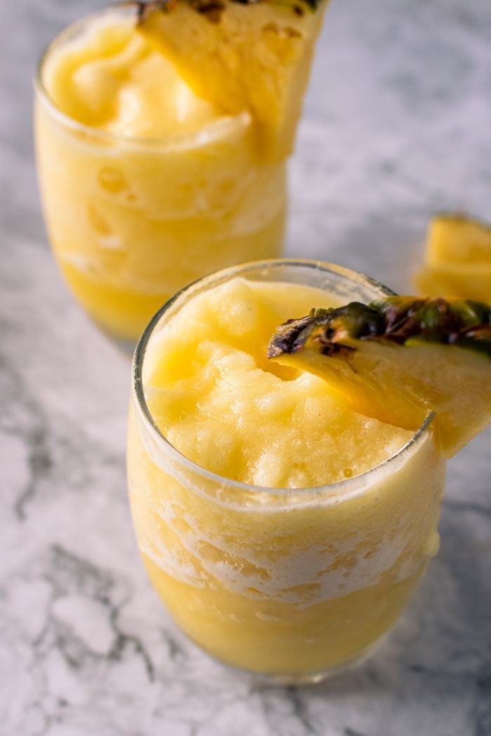 pineapple slushies with a pineapple garnish on the glass